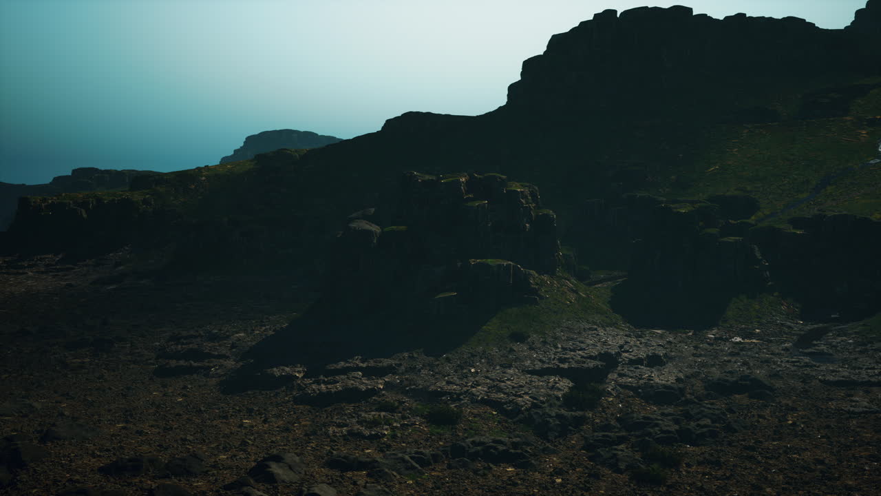 un paisaje montañoso con un pico rocoso y un valle verde exuberante