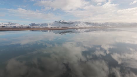 Blue-water-reflecting-sky-white-clouds-in-Icelandic-volcanic-environment-Aerial