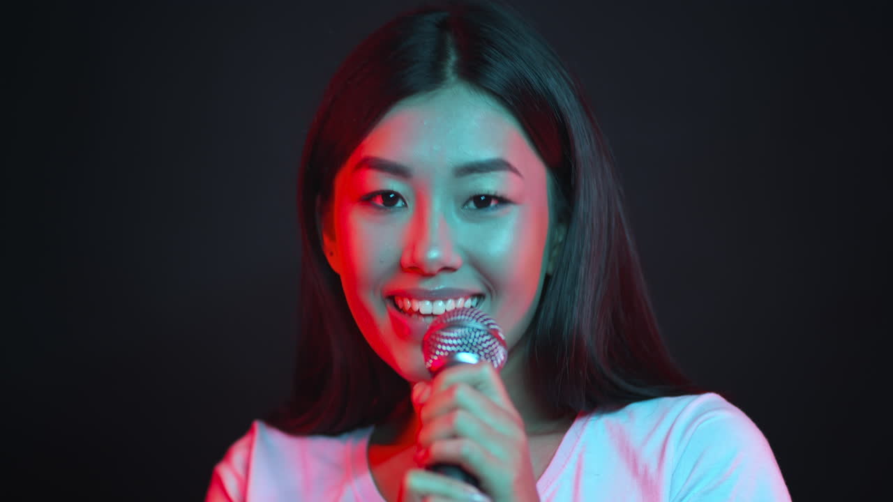 Asian Woman Singing into a Microphone