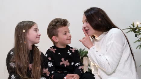 brother and sister are waiting for santa claus brother and sister are waiting for santa claus happy family mom and kids on new years eve on the background of the christmas tree christmas comfort in the house