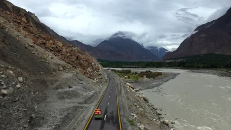 Dramático-Disparo-De-Un-Dron-Después-De-Un-Tuk-tuk-En-La-Autopista-Karakoram-Pakistán-A-Lo-Largo-Del-Río-Hunza