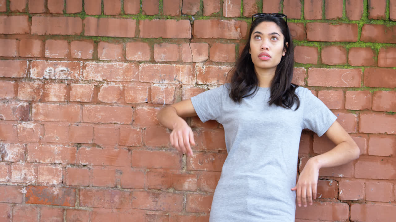 mujer joven de pie contra la pared 4k