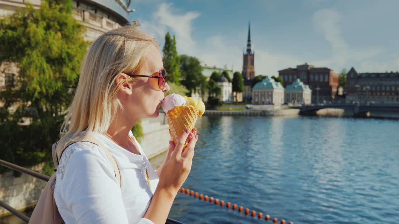 스톡홀름 시의 눈에 띄는 전망을 배경으로 아이스크림을 먹는 여성 관광객