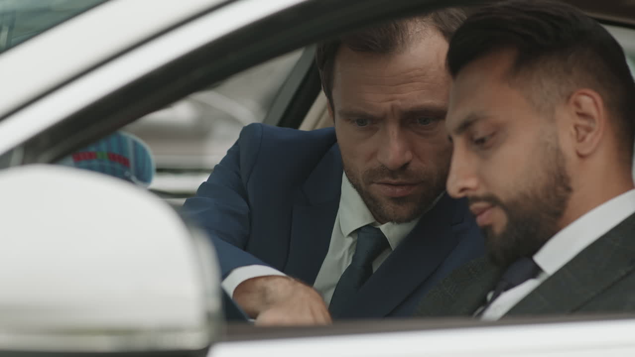 Diverse Businessmen Working in Car