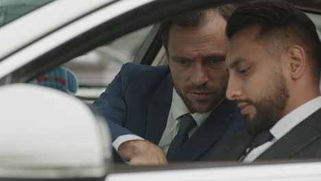 diverse businessmen working in car