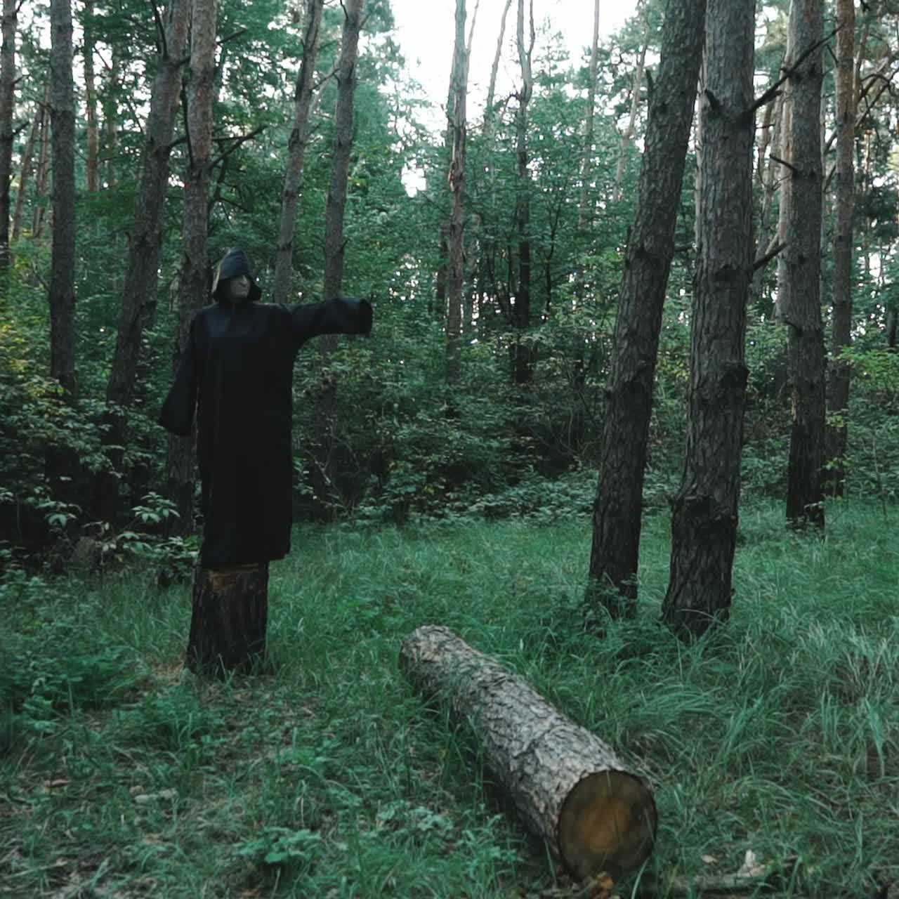 Evil witch in the thicket of the forest. Halloween costume