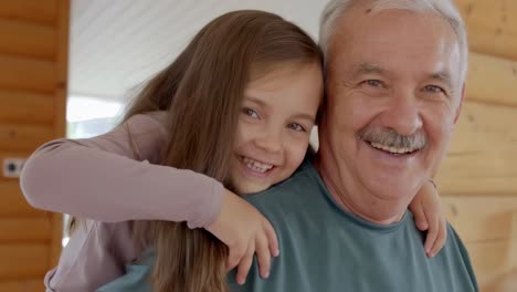 grandfather carrying his granddaughter on his back, both smiling and having fun together in a cozy wooden house, enjoying a special moment of family bonding and creating cherished memories