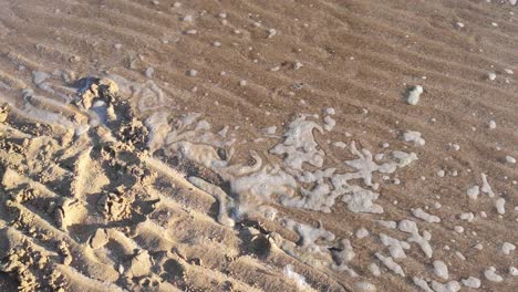 Ozeanflut-Bewegt-Sich-Durch-Gerippte-Goldene-Sandstrandkämme