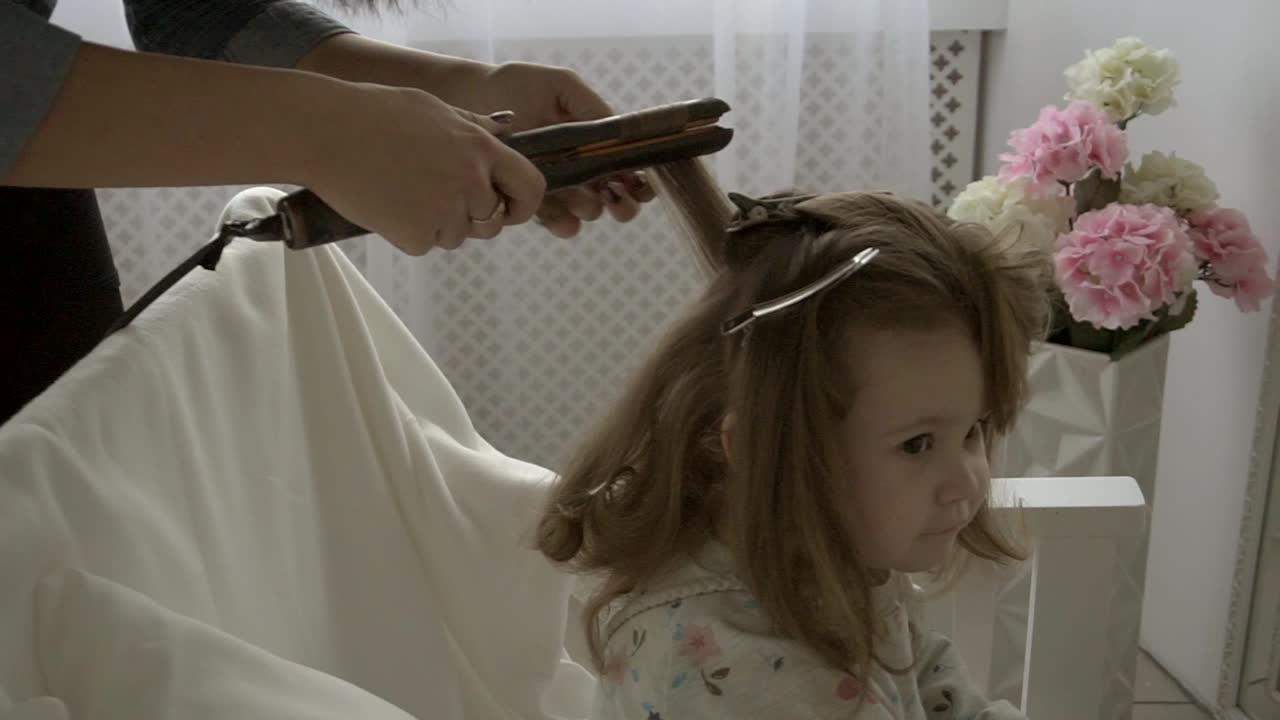 Bambina che si fa acconciare i capelli