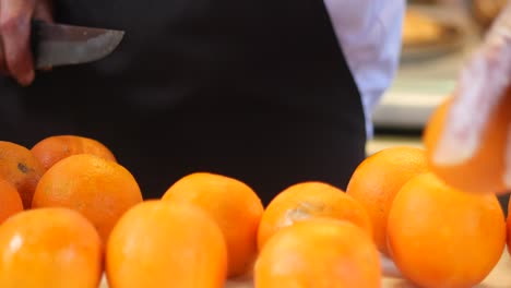 a man cutting oranges for juicing