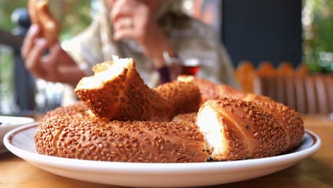 mujer comiendo simit turco con té