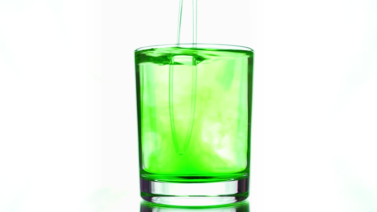 mezcla con un palo de vidrio transparente pigmento verde ácido disuelto en vidrio de agua