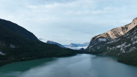 Drone-Volando-Sobre-El-Lago-Molveno-Rodeado-De-Montañas-Dolomitas,-Trentino-En-Italia