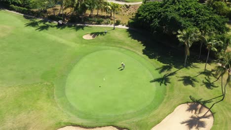 Golf-club-field-with-cart-and-playing-golfers.-Aerial-top-view