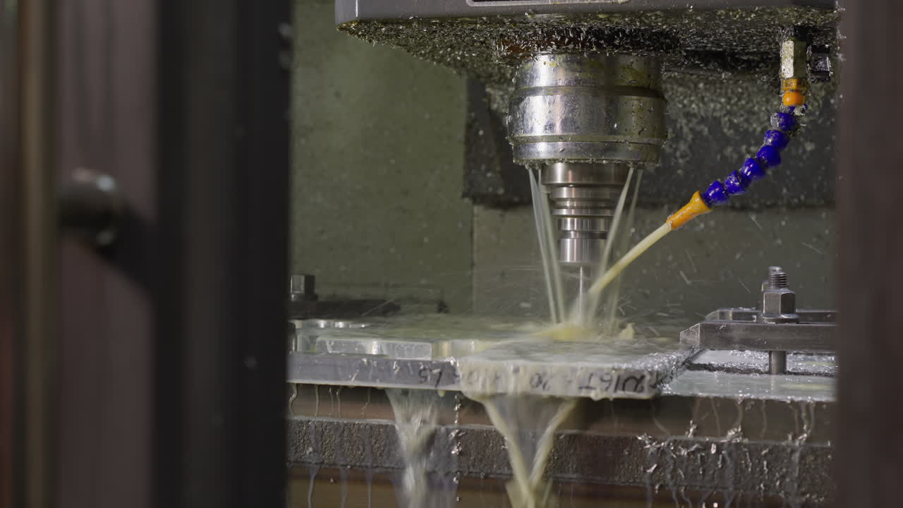 기계 가공 중 금속 부품 에 냉각 용액 을 분사 하는 작업 을 하는 cnc 밀링 머신