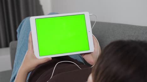 horizontal hands holding watch tablet with green screen at home