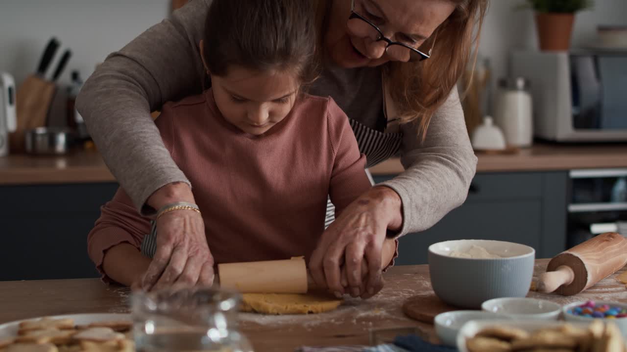 Caucasian senior woman helping a girl with home baking