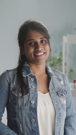 portrait of positive indian woman looking in camera with dazzling smile on face. young female person shows friendly attitude standing near window