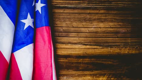 animation of american flag lying on wooden table
