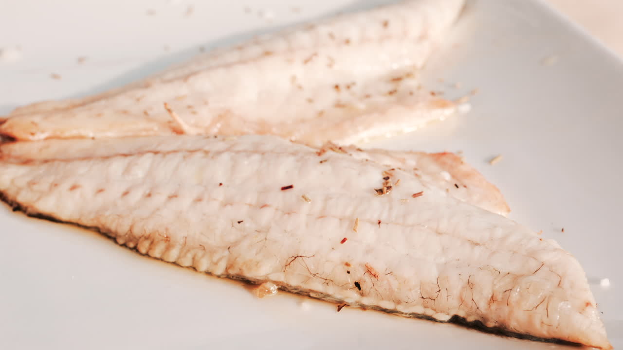 Close up of a freshly grilled white fish fillet seasoned with herbs