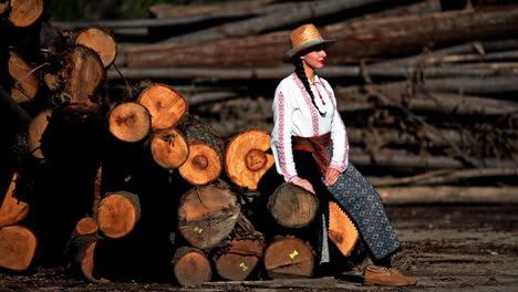 romanian girl sits on the cut trees 3