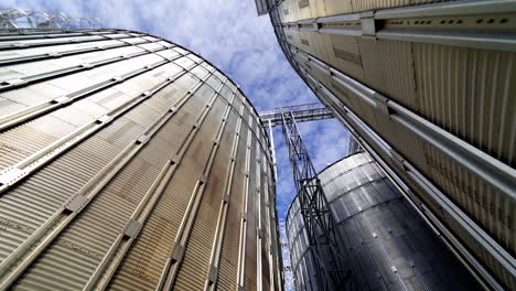 granary grain elevators. metal tanks for the storage crop. large bins for farming. aluminum containers against blue sky. close-up.