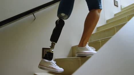 mujer discapacitada con una pierna protésica subiendo las escaleras 4k