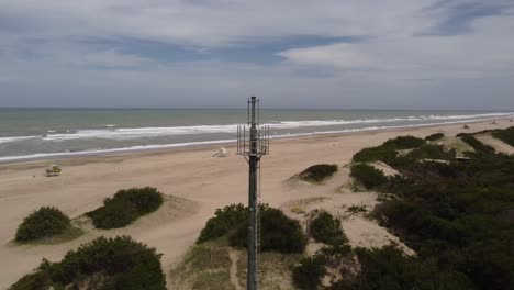 antena en playa desierta con mar de fondo, mar de las pampas en argentina