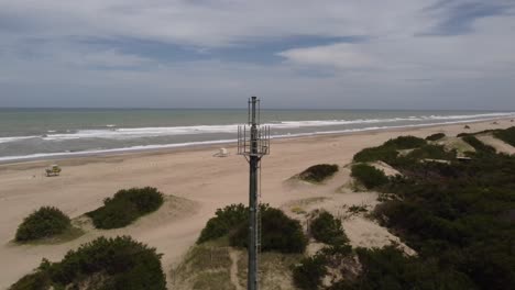 antenna on deserted beach with ocean in background, mar de las pampas in argentina