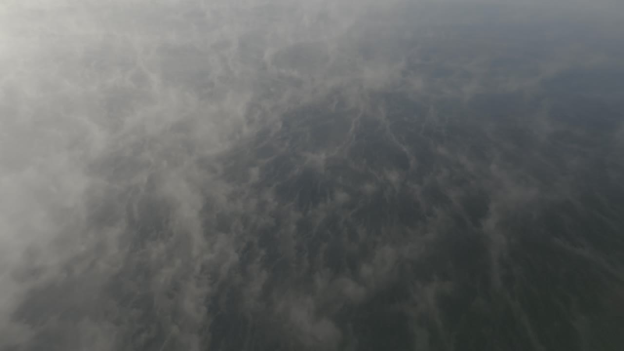 vuelo aéreo panorámico a través de la niebla interminable en la superficie del lago