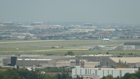 Airplane-descending-and-landing-on-an-airport-runway-at-dawn-on-a-summer-day,-travel-concept