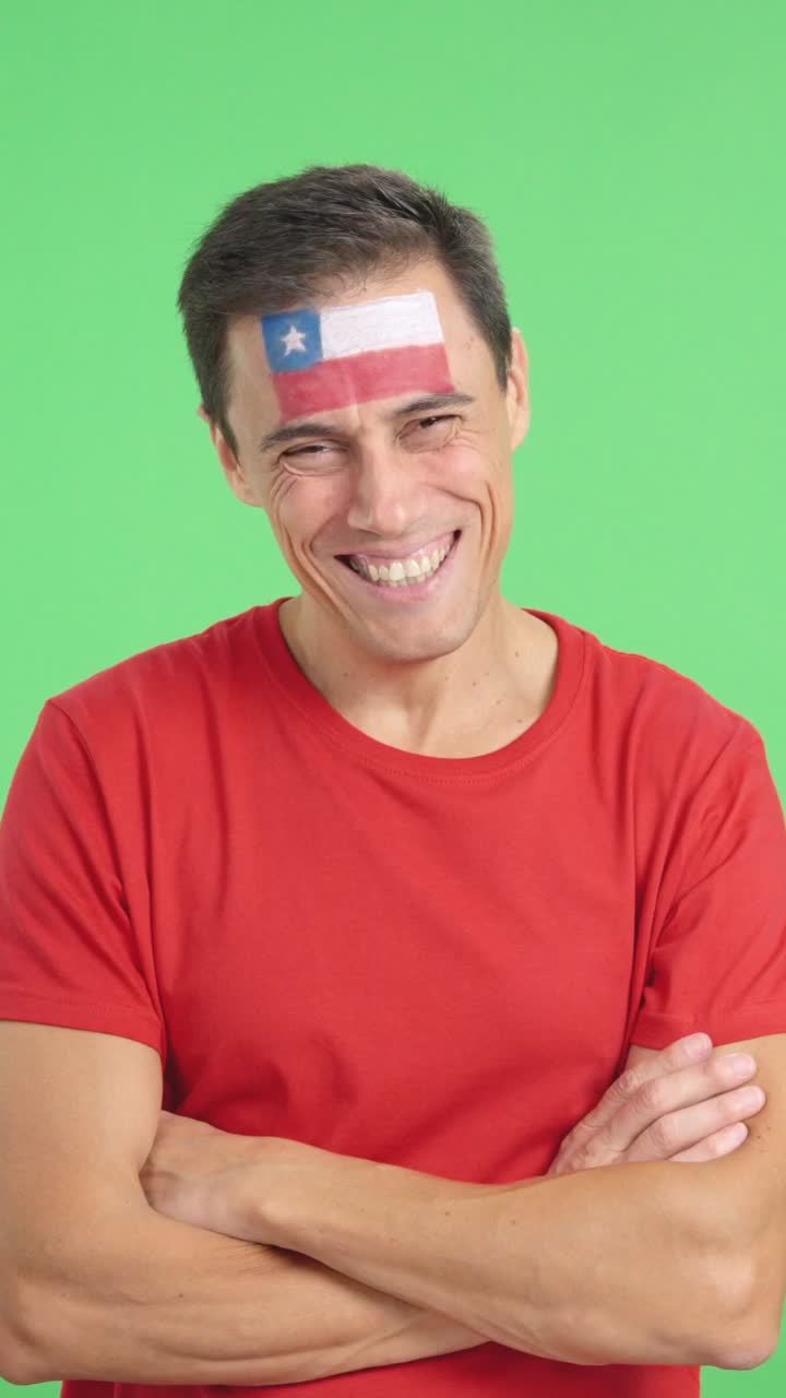 Man standing with chilean flag painted on face smiling