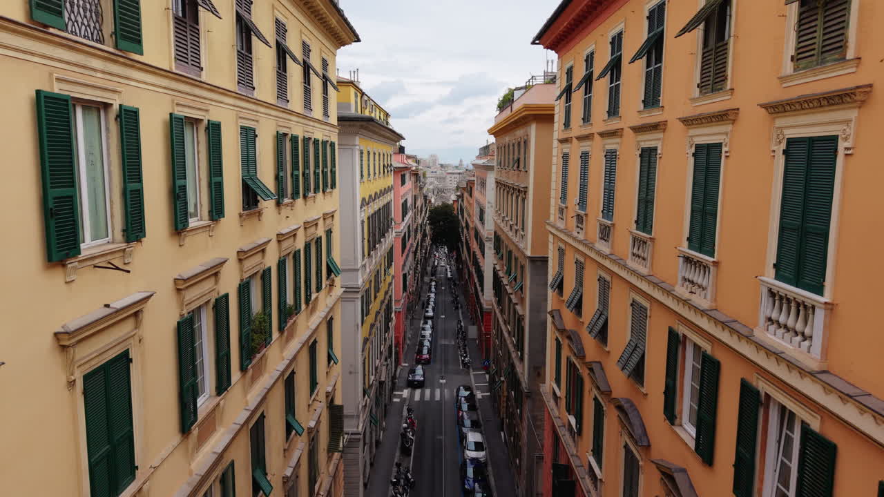 Drone sale sopra i tetti colorati di Genova rivelando il paesaggio urbano e il mare in lontananza
