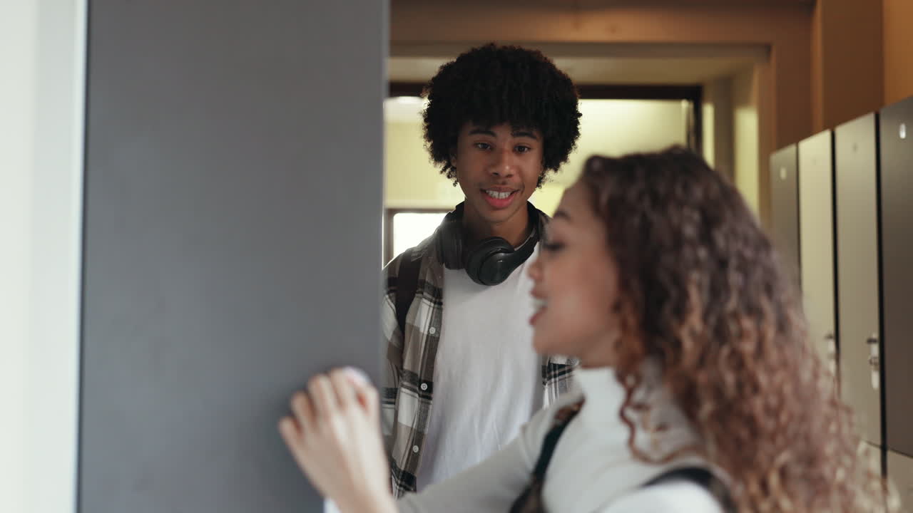 Girl, boy and talking by school locker