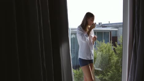 Caucasian-woman-drinking-coffee-in-hotel-room