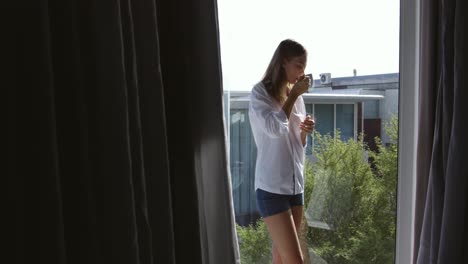 caucasian woman drinking coffee in hotel room