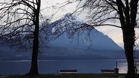 Hermoso-Paisaje-Lacustre-Con-Montañas-Cubiertas-De-Nieve-En-El-Fondo