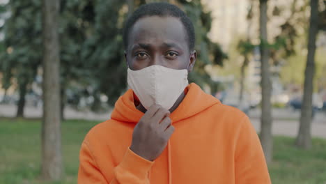 man adjusting face mask outdoors