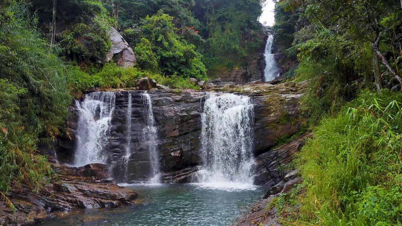 Fast flowing Kadiyanlena falls cascading three tier waterfall on Mahaweli river in Kandy District of Sri Lanka