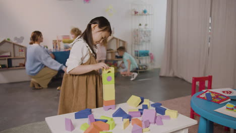 little girl playing with foam building blocks in a montessori school