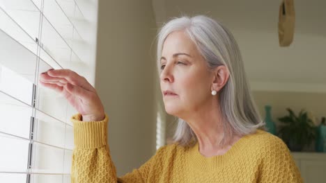 senior caucasian woman thinking and looking through window