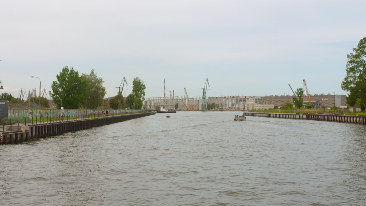 Front view of Gdansk Industrial port, one of Europe's most important, with cranes on duty in Gdansk, Poland during daytime. View from boat.