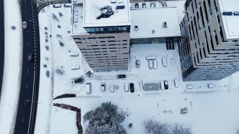 car leaving a high-rise residential complex in a winter landscape