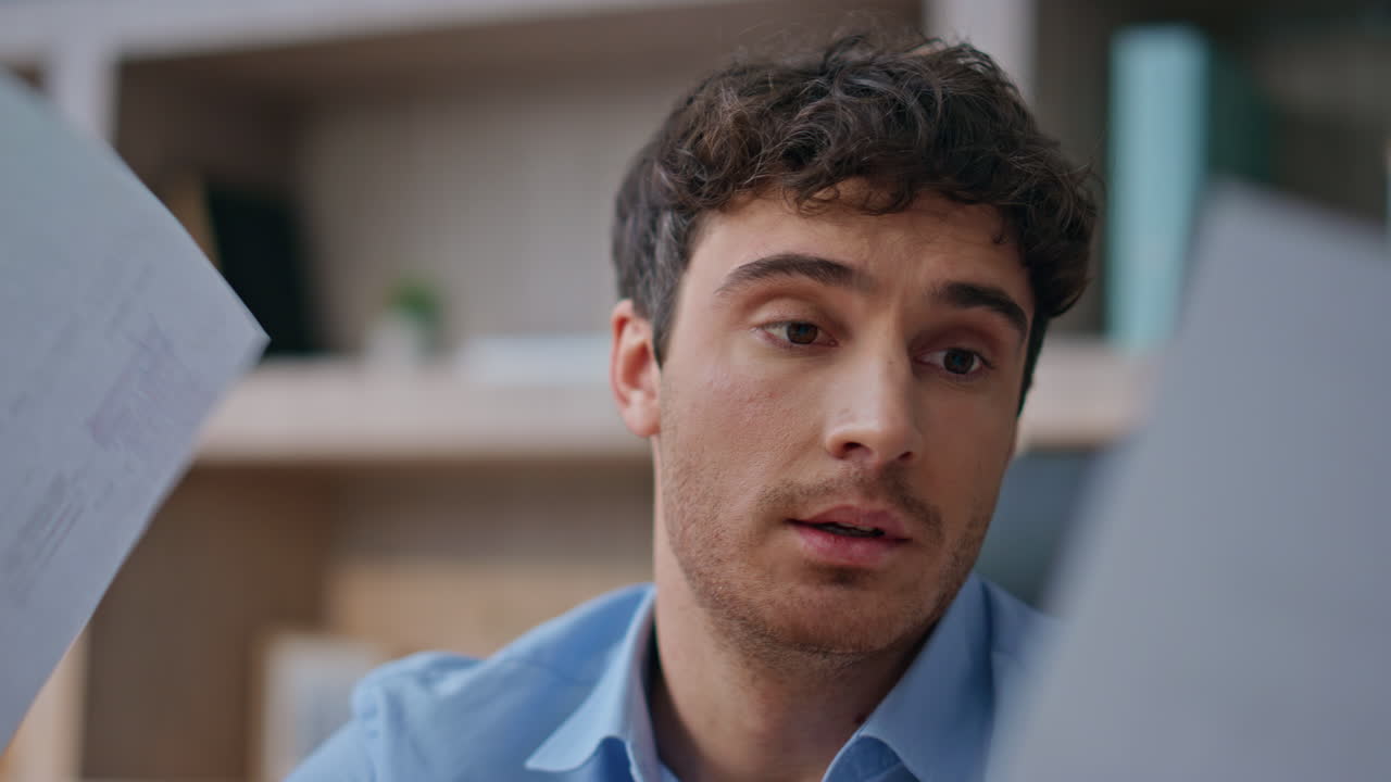 Worried businessman analysing papers in office closeup. Concerned man reading