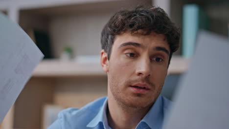 worried businessman analysing papers in office closeup. concerned man reading