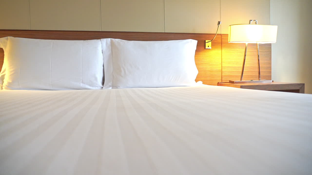 호텔 침대 중간 세기의 현대적인 램프를 가로질러 이동