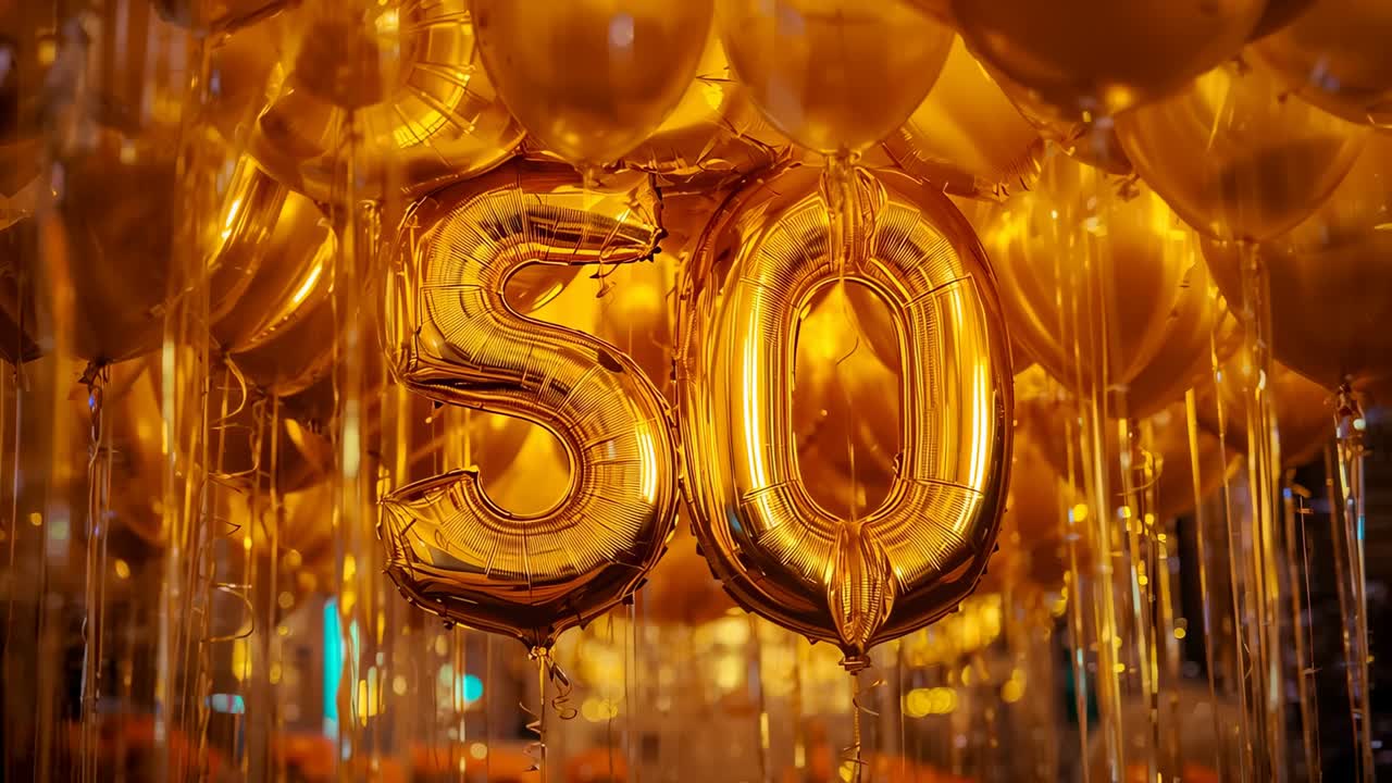 Swaying from air, gold numeral balloons forming 50 catching light at 50th celebration, with ribbons