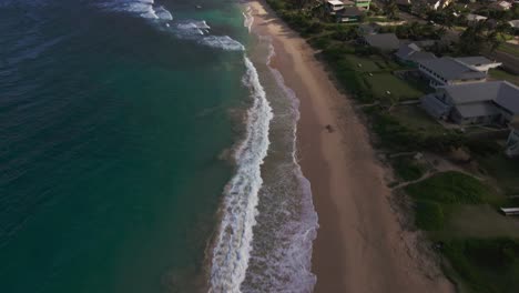 drone pans hukilau beach revealing stunnning tropical landscape,crystal clear water