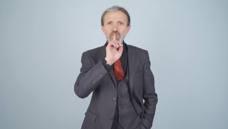 hombre de negocios diciendo callarse a la cámara.