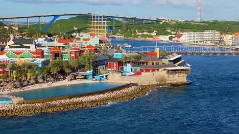 aerial pan across mall and hotel infinity pool below queen juliana bridge in willemstad curacao